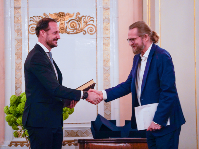 Kronprins Haakon får praktutgåva av Magnus Lagabøtes landslov frå nasjonalbibliotekar Aslak Sira Myhre under mottakinga. Foto: Terje Pedersen / NTB 